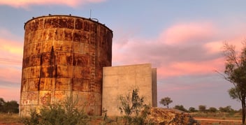 The rusty derelict water tank which now houses the sound chapel. The entry is between the concrete walls, the same size as the cube inside.