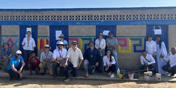 Hunter Water and WaterAid teams work with a local artist to paint this newly constructed toilet block with traditional artwork in the La Gloria region of La Guajira